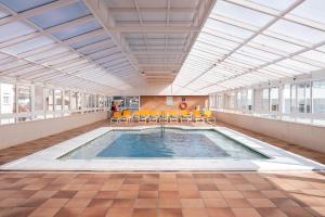 a large swimming pool in a building with a ceiling at Port Fiesta Park in Benidorm