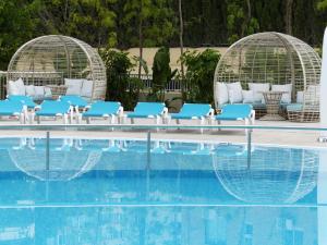a row of blue chairs next to a swimming pool at Port Benidorm Hotel & Spa 4* Sup in Benidorm
