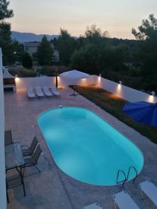 a swimming pool in a backyard with a blue light at Villa Marinos in Kalamaki