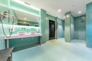 a bathroom with two sinks and green tiles at Port Benidorm Hotel & Spa 4* Sup in Benidorm