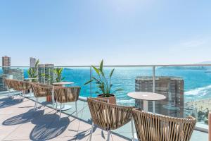 a balcony with chairs and tables and the ocean at Port Benidorm Hotel & Spa 4* Sup in Benidorm