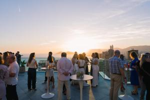 a group of people standing on a roof looking at the sunset at Port Benidorm Hotel & Spa 4* Sup in Benidorm