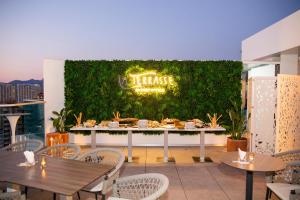 a restaurant with tables and chairs and a green wall at Port Benidorm Hotel & Spa 4* Sup in Benidorm