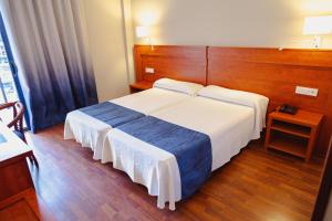a bedroom with a large bed with a wooden headboard at Port Denia in Denia