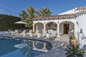 une villa avec une piscine, des chaises et une maison dans l'établissement Villa Artista, à Jávea