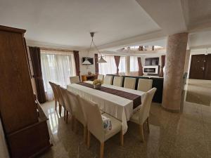 a dining room with a table and chairs at Elegant Private Villa with 3 Bedrooms, Office, and shared courtyard, Perfect for 8 Guests in Piteşti