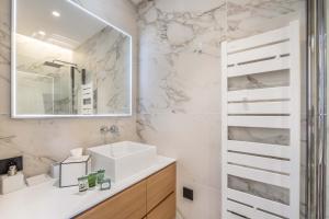 un baño con lavabo y espejo en Villa Bleu Rivage - Villa les pieds dans l'eau, en Veyrier-du-Lac 10 fotos más