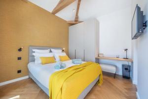 Un dormitorio con una cama grande con sábanas amarillas. en Villa Bleu Rivage - Villa les pieds dans l'eau, en Veyrier-du-Lac