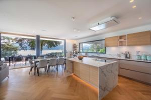 Una cocina y un comedor con mesa y sillas. en Villa Bleu Rivage - Villa les pieds dans l'eau, en Veyrier-du-Lac