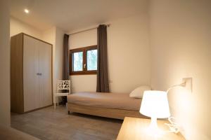 a bedroom with a bed and a window and a lamp at saracena Holiday Home with Private Beach and Swimming Pool in Mattinata +97 photos