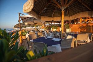 a restaurant with tables and chairs and an umbrella at saracena Holiday Home with Private Beach and Swimming Pool in Mattinata