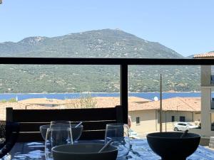 una mesa con gafas y vistas a la montaña en Nouveauté ! Bel'Orizonte T - Deux Chambres proche mer, en Propriano