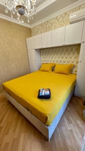 a bedroom with a large bed with a yellow bedspread at Friends Premium HOSTEL in Baku