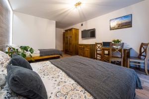 a bedroom with a bed and a dining room with a table at Agroturystyka Folwarczek Pokoje i Apartamenty in Ustroń