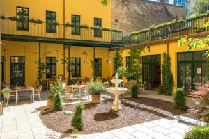 un patio con un edificio amarillo con una fuente en Augarten Apartments, en Viena