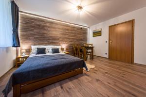 a bedroom with a bed and a wooden wall at Agroturystyka Folwarczek Pokoje i Apartamenty in Ustroń +55 photos