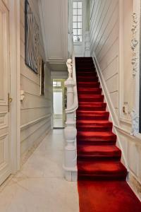 a red carpeted staircase in a home with a white stair case at Le Papillon Antwerp Suite 3 in Antwerp