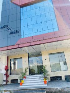 a building with stairs and potted plants in front of it at Taj Comfort Inn in Agra +32 photos