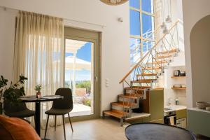 a living room with a staircase and a table and chairs at Nikiti Dream Villas in Nikiti
