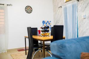 a dining room table with two chairs and a table with bottles of wine at Appartement HAVRE DE PAIX in Abomey-Calavi +14 photos