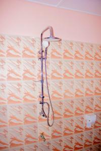 a shower with a shower head on a wall at Appartement HAVRE DE PAIX in Abomey-Calavi