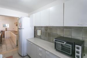 a kitchen with a white refrigerator and a microwave at Villa Cristina a marina di Capilungo - Apulia Home in Capilungo