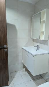 a white bathroom with a sink and a mirror at Dragon Premium Homes in Dubai