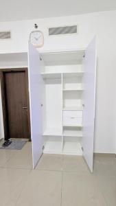 a closet with white shelves and a clock on the ceiling at Dragon Premium Homes in Dubai