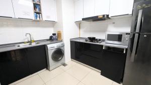 a kitchen with a washing machine and a microwave at Dragon Premium Homes in Dubai