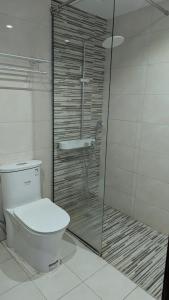 a bathroom with a toilet and a glass shower at Dragon Premium Homes in Dubai +2 photos