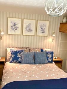a bedroom with a bed with blue and white pillows at Cosy 3 bedroom cottage by the sea in Aberdovey in Aberdyfi