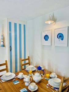 a dining room table with plates and cups on it at Cosy 3 bedroom cottage by the sea in Aberdovey in Aberdyfi
