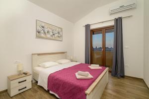 a bedroom with a large bed with a pink blanket at Villa RE by Istrialux in Svetvinčenat +24 photos