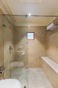 a bathroom with a shower and a tub and a sink at SaffronStays Sylvan Farms in Delmāra