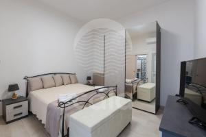 een slaapkamer met een bed, een spiegel en een tv bij Villa Chicadee - piscina privata - by Cala Salento in Campomarino +60 foto's