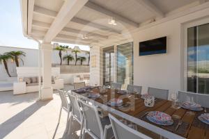 een eetkamer met een tafel en stoelen bij Villa Chicadee - piscina privata - by Cala Salento in Campomarino