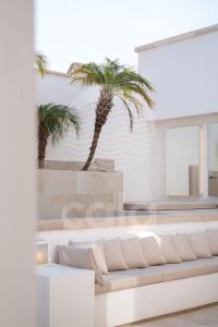 een woonkamer met palmbomen en een bank bij Villa Chicadee - piscina privata - by Cala Salento in Campomarino
