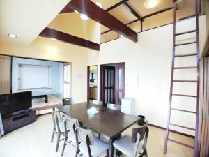 Un comedor con mesa y sillas en 絶景温泉付き別荘, en Higashiizu