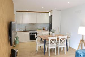 a kitchen with a table and chairs in a room at Dunas Ria Apartment T2 in Gafanha da Encarnação
