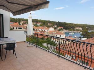 een balkon met een tafel, een parasol en uitzicht bij Apartment Sea view in Vrboska
