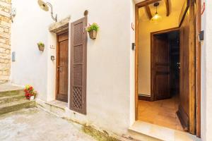 een ingang naar een gebouw met een deur en bloemen bij Le Fanciulle - Anita in Baunei
