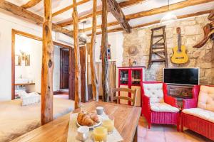 een woonkamer met een tafel en een rotswand bij Le Fanciulle - Anita in Baunei