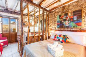 een slaapkamer met een bed en een stenen muur bij Le Fanciulle - Anita in Baunei