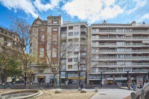 a large building with a fountain in front of it at BBarcelona Gracia Apartment in Barcelona