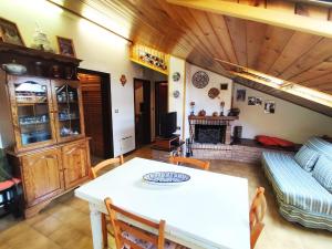a living room with a table and a couch at Mansarda Elena in Sestola