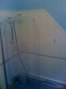 a shower with a glass door in a bathroom at Newcourt B & B in Llantwit Major