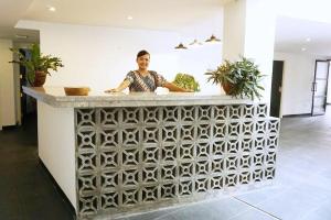 a man standing at a counter in a kitchen at Taman Unique Hotel Senggigi in Senggigi  +81 photos