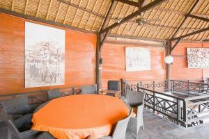 a dining room with an orange table and chairs at Taman Unique Hotel Senggigi in Senggigi 