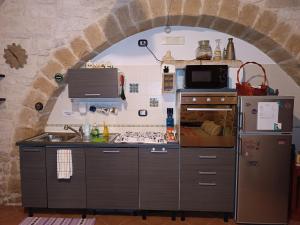 a kitchen with an archway in a stone wall at Unique white stone Studio in Giovinazzo