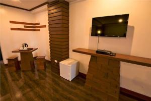 Habitación con TV en la pared y mesa. en Abozza Resort, en Boracay